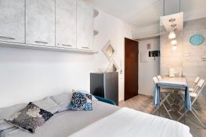 Cet appartement comprend une chambre avec un lit et une table ainsi qu'une cuisine. dans l'établissement Il Turchese, à Sanremo