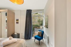 a bedroom with a bed and a blue chair at Rock Mill Apartment 10 in Eyam