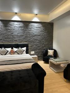 una camera con letto e muro di mattoni di The Origin Suites DLF MY PAD a Lucknow