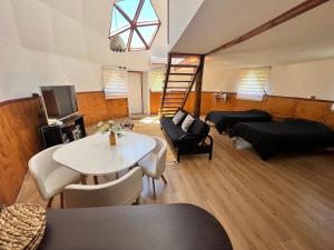 a living room with a table and chairs and a staircase at Domos chucauco in Villarrica