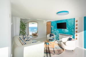 Laguna Blu - Resort Villa overlooking the sea on the Amalfi Coast في فيتري: غرفة معيشة مع أريكة بيضاء وجدران زرقاء