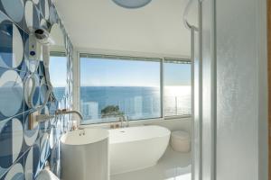 a bathroom with a tub and a sink and a window at Laguna Blu - Resort Villa overlooking the sea on the Amalfi Coast in Vietri