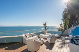 Laguna Blu - Resort Villa overlooking the sea on the Amalfi Coast في فيتري: شرفة مع كراسي وإطلالة على المحيط