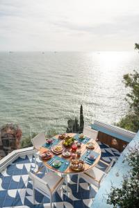 a table with plates of food on a balcony with the ocean at Laguna Blu in Vietri sul Mare