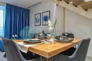 comedor con mesa de madera y sillas en Spacious 2 Bedroom In Oasis, en Al Qurayyah