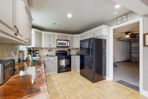 a kitchen with white cabinets and a stainless steel refrigerator at Paradise Dream Vacations #2 in Indialantic