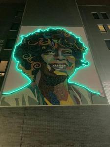 a painting of a woman with curly hair on a wall at 2 Bedroom 1 Bathroom Free Parking Dwntwn Newark in Newark