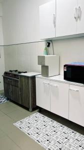 a kitchen with white cabinets and a stove at Putrajaya Homestay (Zurinn 2) in Putrajaya