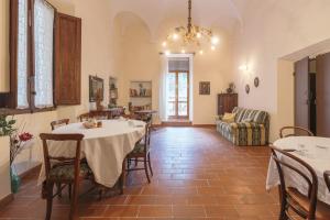 een eetkamer met een tafel en stoelen en een bank bij A Palazzo in Pergola