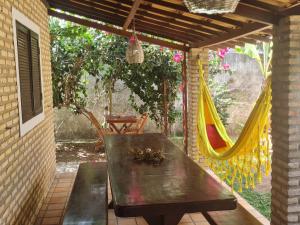 a patio with a table and a hammock at Porto do Sol - Chalé 25 in Pipa