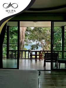a bedroom with a bed and a view of a tree at Mupa Resort in Ko Jum