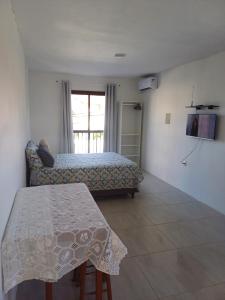 a bedroom with a bed and a table and a tv at Pousada Vista da Lagoa in Florianópolis