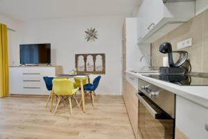 a kitchen with a table and chairs in a room at Standard Apartment by Hi5-Horváth Mihály square in Budapest +13 photos
