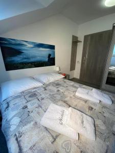 ein Schlafzimmer mit einem großen Bett mit Handtüchern darauf in der Unterkunft Natalii in Kudowa-Zdrój