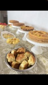 uma mesa com tartes e outras sobremesas em pratos em Rochas pousada em Carolina