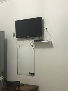 TV de pantalla plana en la pared con espejo en Rochas pousada, en Carolina