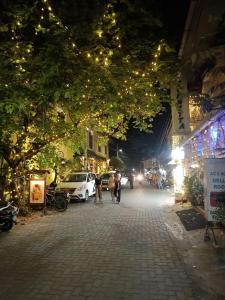 Pessoas andando pela rua à noite com luzes de Natal em ELZAS FORTINN Homestay Fortkochin,kochi em Cochin