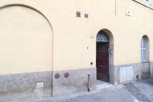 um edifício com dois arcos e uma porta castanha em the house outside the walls em Siena