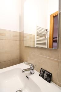 um lavatório de casa de banho com uma torneira e um espelho em the house outside the walls em Siena