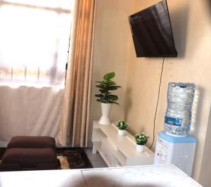 salon z telewizorem na ścianie w obiekcie Mahnoor Airbnb Mombasa w mieście Mombasa