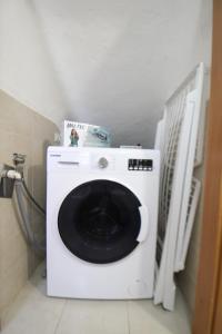 uma máquina de lavar roupa branca na casa de banho com em the house outside the walls em Siena