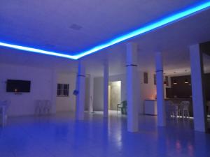 um quarto branco com luzes azuis no tecto em Casa com Piscina, hidromassagem e churrasqueira. em Canoa Quebrada