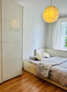 a bedroom with a bed and a chandelier at 300m od Rynku Sinus Apartaments in Wejherowo