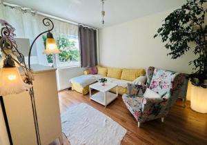 a living room with a couch and a chair at 300m od Rynku Sinus Apartaments in Wejherowo