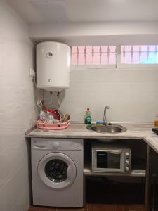 eine Küche mit einer Waschmaschine und einem Waschbecken in der Unterkunft Apartamento Triana in Alovera