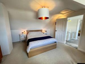 een slaapkamer met een groot bed en een groot licht bij Comfortable, modern family home in St. Agnes in St. Agnes 
