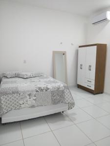 ein weißes Schlafzimmer mit einem Bett und einer Kommode in der Unterkunft Casa com Piscina, hidromassagem e churrasqueira. in Canoa Quebrada