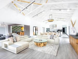 a living room with white furniture and a table at Panorama Villa in Graskop