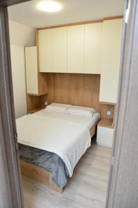 um quarto com uma cama grande e armários brancos em Vila ALIBI em Kopaonik
