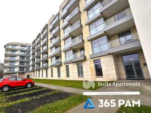 a red car parked in front of a building at 365PAM - Szum Morza - Apartament w Diune in Kołobrzeg