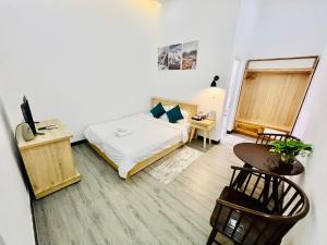 sypialnia z łóżkiem, stołem i biurkiem w obiekcie D'Villa Hotel - Homestay w mieście Kon Tum