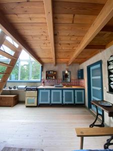 uma cozinha com armários azuis e um tecto de madeira em Artist Studio em Frederiksværk