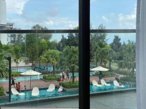 a view of a swimming pool from a window at TimurBay Seafront ZarZyra Suite in Kuantan
