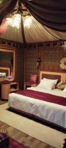 a bedroom with a large bed and a desk at Hakuna matata desert camp in Wadi Rum