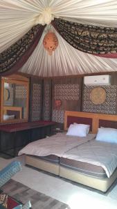 a bedroom with a large bed with a canopy at Hakuna matata desert camp in Wadi Rum