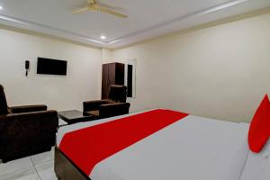 a hotel room with a bed and two chairs at Hotel CJ Pride in Vijayawāda