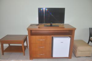 a wooden desk with a television and a stool at Flat em Resort Paradisíaco! in Angra dos Reis