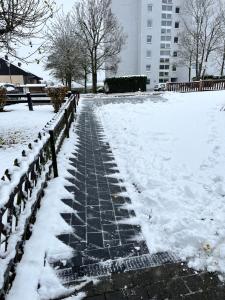 a snow covered walkway with snow on it at Ferienwohnung LINA in Bitburg