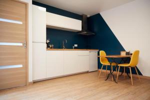 een keuken met witte kasten en een tafel en stoelen bij Superbe grange réaménagée in Fampoux