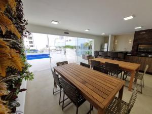 ein Restaurant mit Holztischen und -stühlen und einem Pool in der Unterkunft JH PALHANO in Londrina