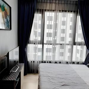 a bedroom with a bed and a large window at THE BASE apartments at central pattaya in Pattaya Central