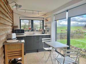 een keuken met een tafel en stoelen en een raam bij Hedges House in Buckingham