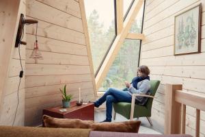 une femme assise sur une chaise dans une pièce avec fenêtre dans l'établissement Trasti & Trine Boutique Hotel, à Alta