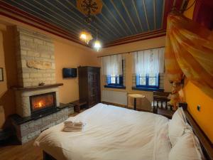 a bedroom with a large bed and a fireplace at Archontiko Zarkada in Monodendri