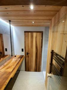 um quarto com uma cama e uma porta de madeira em Chalet Fleur des Vosges 5 Bedrooms em La Bresse