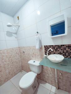 a bathroom with a toilet and a sink at Pousada Dule in Guarapari